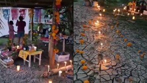 Una mujer y una niña montan una ofrenda de día de muertos en un terreno de lodo.