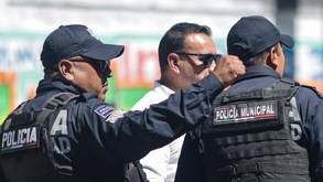 Dos hombres vestidos con uniforme policial vistos de espaldas.