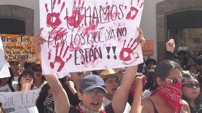 Estudiantes en manifestación por violencia en Michoacán con un cartel