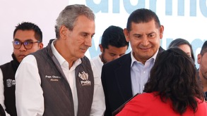 Dos hombres de camisa blanca platicando con mujer vestida de rojo.
