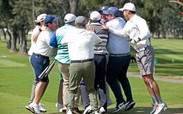 Gurpo de hombres festejando sobre campo de golf