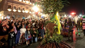 Un hombre disfrazado de catrina con grandes plumas cautivó en el Desfile Xantolum 2025 en Saltillo.