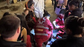 Mujer con herida en la pierna y disfrazada, alrededor personas auxiliándola, así como paramédicos de Cruz Roja Mexicana.