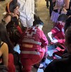 Mujer con herida en la pierna y disfrazada, alrededor personas auxiliándola, así como paramédicos de Cruz Roja Mexicana.