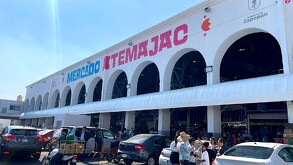 Facha de exterior del Mercado de Atemajac en Zapopan, familias realizando compras y autos estacionados alrededor