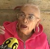 Mujer de la tercera edad con cabello rubio y lentes hablando al micrófono de canal 6