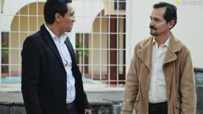 dos hombres platicando, uno vestido con una chamarra café y el otro de negro