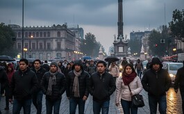 Personas caminando abrigadas por el Ángel de la Independencia
