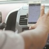 El conductor de alquiler de aplicación está buscando una dirección en google maps en su celular.