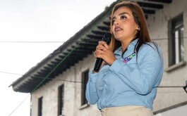 Grecia Quiroz tomando un micrófono