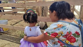 Madre e hija disfrutando de la convivencia con los animales de la Granja Las Américas en Ciudad de México.