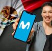 Mujer sosteniendo celular con imagen de Movistar y de fondo una bandera de México.
