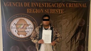 Un hombre con cintilla negra en ojos y sudadera presentado ante la Agencia de Investigación Criminal.