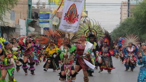 Varios danzantes aztecas con un estandarte blanco de la Virgen de Guadalupe