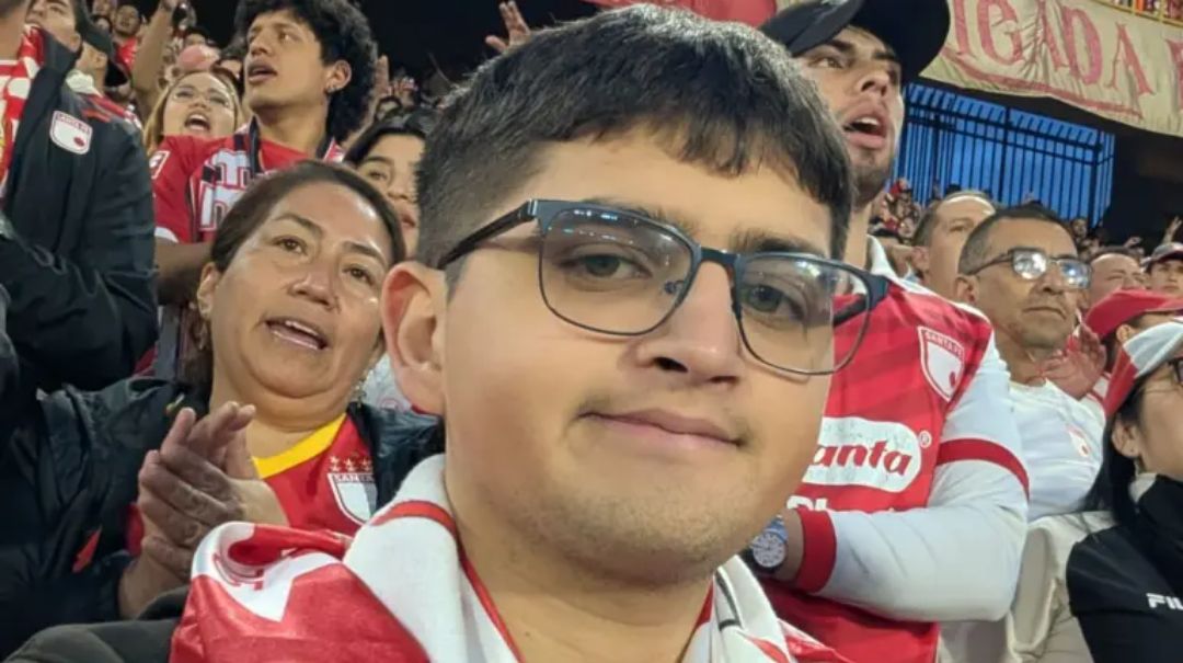 Joven con lentes y bufanda de un equipo de futbol