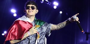 junior h con una bandera mexicana en un concierto