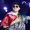 junior h con una bandera mexicana en un concierto