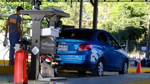 Automóvil de la marca Chevrolet color azul realizando la verificación en Jalisco. A un lado una se encuentra una persona y al frente un extintor.