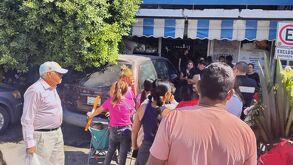 Grupo de personas rodeando un carro que quedó dentro de una tienda en el centro de Torreón