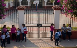 Escuela cerrada con niños y familias esperando, generada con Gemini IA