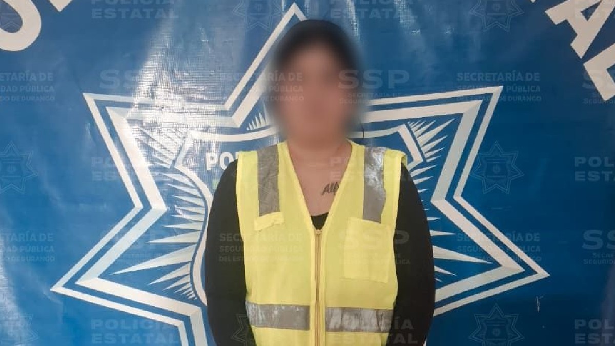 Mujer con el rostro censurado, con una blusa negra y chaleco en color verde