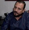 El titular de la Profeco en una entrevista. Es un hombre con barba de candado y camisa de mezclilla, sentado en un escritorio de oficina con la bandera de Méxic