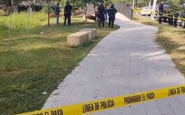 Camellón con cinta de precaución y elementos de policía de fondo