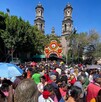 Gente caminando al aire libre hacia la Iglesia de San Judas Tadeo en la Ciudad de México.