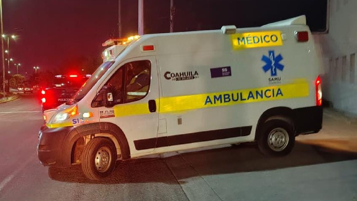 Ambulancia en color blanco y amarillo estacionada sobre la banqueta