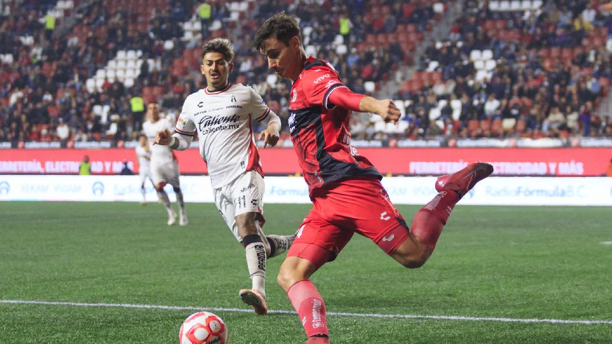 Unai Bilbao despejando un balón ante la marca de Diego González del Atlas en el partido contra Xolos.