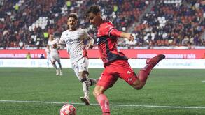 Unai Bilbao despejando un balón ante la marca de Diego González del Atlas en el partido contra Xolos.
