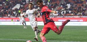 Unai Bilbao despejando un balón ante la marca de Diego González del Atlas en el partido contra Xolos.