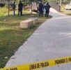 Camellón con cinta de precaución y elementos de policía de fondo