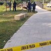 Camellón con cinta de precaución y elementos de policía de fondo