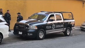 Patrulla de la Policía de Guadalajara estacionada detrás de camioneta blanca con policías al lado derecho