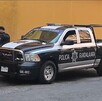 Patrulla de la Policía de Guadalajara estacionada detrás de camioneta blanca con policías al lado derecho