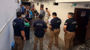 Oficiales de la Policía de Investigación de Jalisco frente a personas internadas en un anexo de Tlajomulco