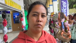 Mujer con semblante serio y mirada perdida, vestida con una sudadera naranja.