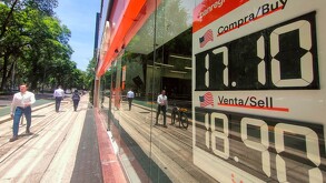 Ventanilla de banco con precio del dólar.