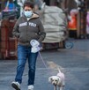 Mujer paseando su perro con cubrebocas por mala calidad del aire.