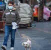 Mujer paseando su perro con cubrebocas por mala calidad del aire.