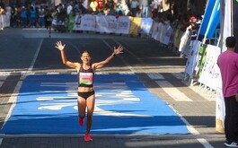 Mujer con prendas deportivas celebrando eon calle