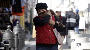 una mujer abrigada y cubierta de la cara por el frente frío en puebla