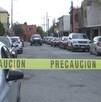 Hay carros estacionados y una cinta de precaución amarilla, además al fondo se encuentra una patrulla.