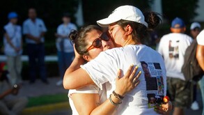 Madres y familiares de personas desaparecidas en jalisco dándose un abrazo vistiendo playeras con fichas de búsqueda en medio de la calle