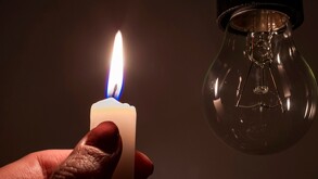 Una vela junto a un foco sin luz