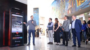 Juan José Frangie en un podio interactivo (tótem digital) con el mensaje 