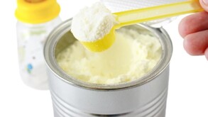 Biberón y frasco con fórmula para bebé en color amarillo con cucharon del mismo color