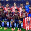 El equipo de fútbol Club Deportivo Guadalajara (Chivas) posa en la cancha antes de un partido. Los 11 jugadores visten su uniforme de rayas rojo y blanco