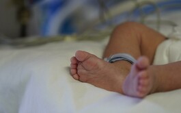 Pies de un bebé sobre una cama de hospital